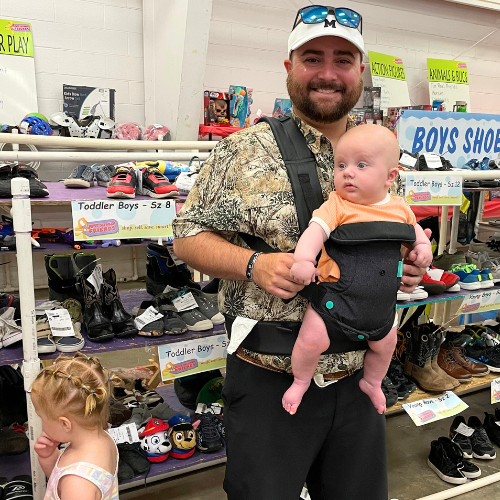 Dad baby wearing at a JBF sale. 